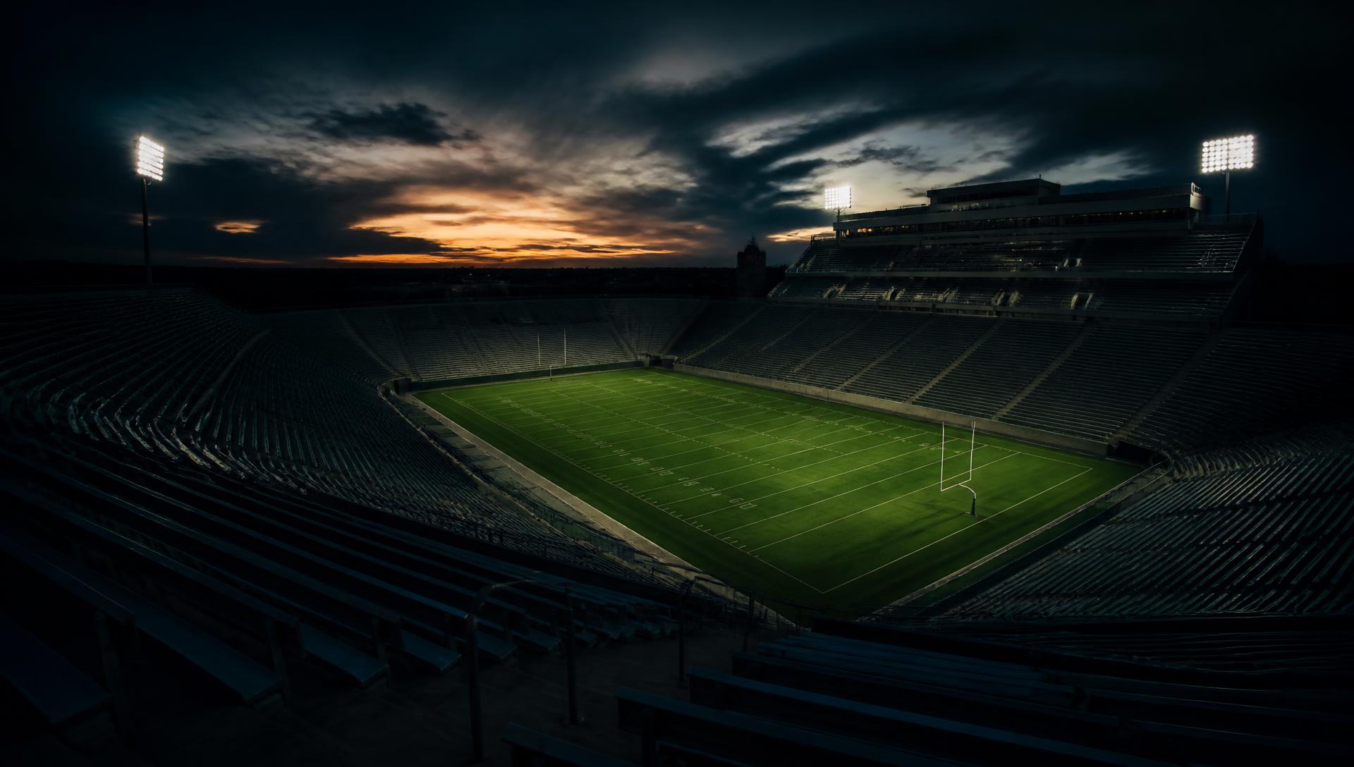 A packed collegiate stadium under the lights on game day